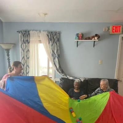 Residents enjoying a parachute activity with staff