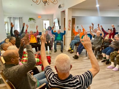 Residents engaging in an activity with raised hands