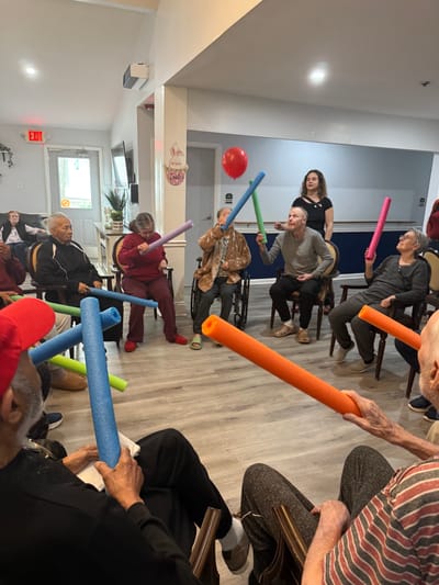 Residents participating in an interactive activity with pool noodles