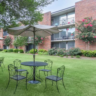 Outdoor seating area with tables and umbrellas.
