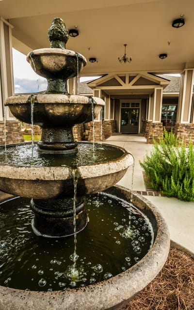 A decorative fountain in front of the facility entrance