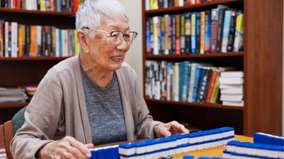 Resident playing mahjong in a cozy library