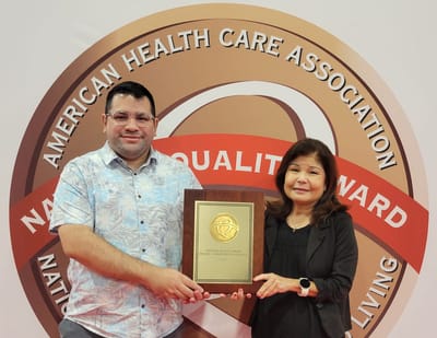 Two staff members holding an award plaque.