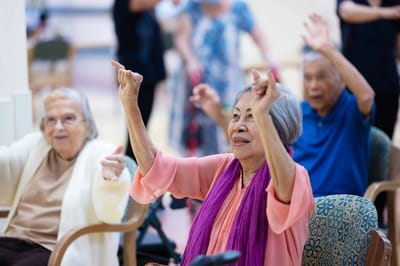 Residents engaged in an activity with staff in a bright common area