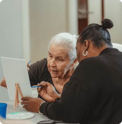 A resident and staff member engaged in an arts activity