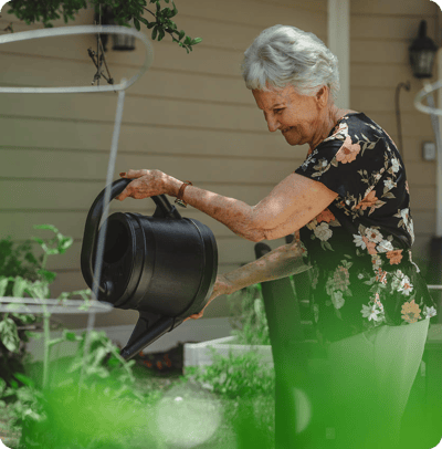 Senior woman watering plants in a garden