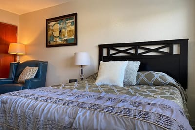 Cozy bedroom with bed, chair, and artwork