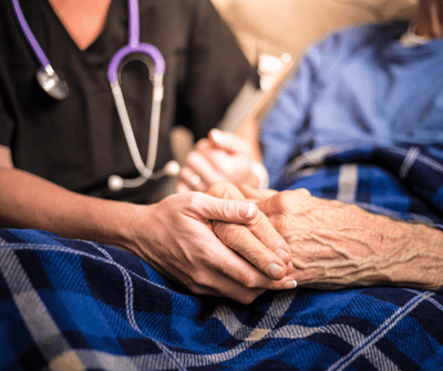 A caregiver holding the hand of a resident