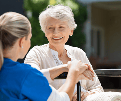 A caregiver and resident enjoying a conversation outdoors