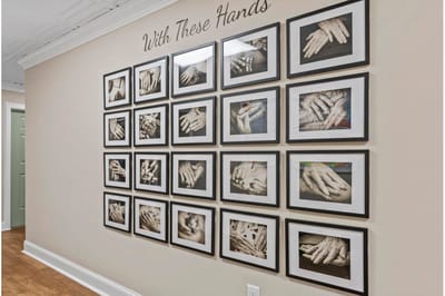 Gallery wall with framed black and white photos of hands