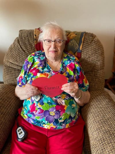 Resident holding a heart-shaped sign with her name