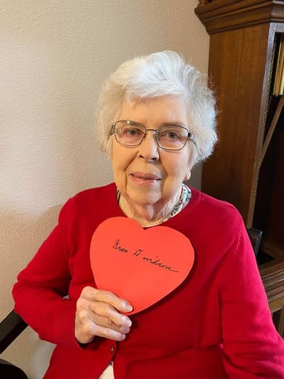 Resident holding a heart-shaped sign, smiling