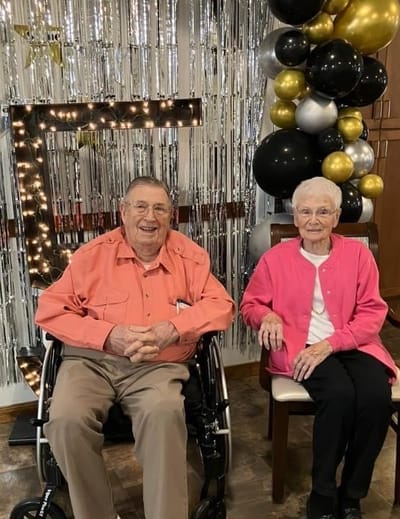 Two residents smiling together in a decorated common area