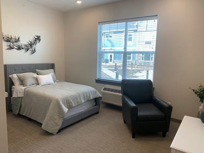 A cozy resident room with a bed and seating area