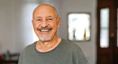 Happy senior man smiling in a living space