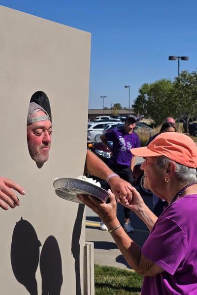 Residents enjoying a fun pie-throwing activity outdoors