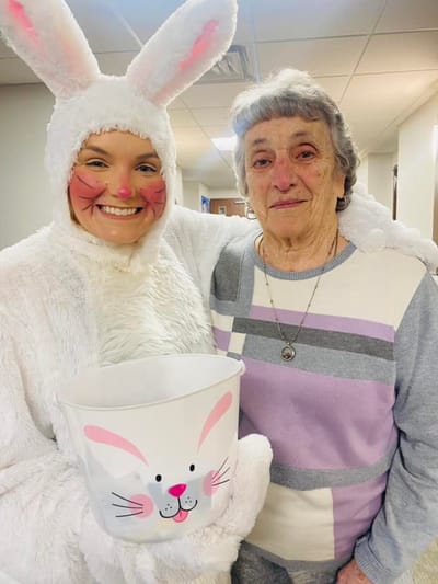 Staff member in a bunny costume with a resident