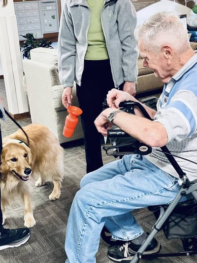 Senior resident interacting with a dog in a common area