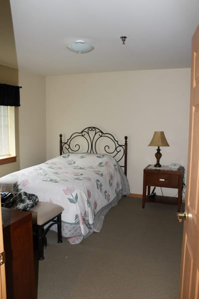 Cozy bedroom with a floral quilt and lamp
