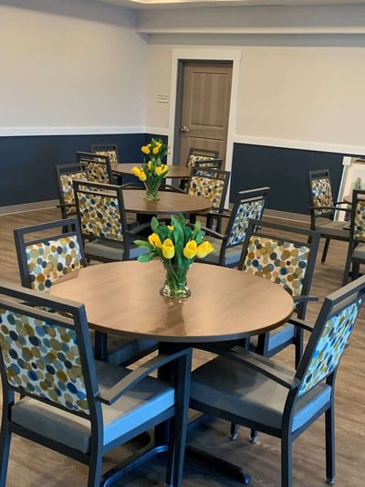 Brightly lit common area with tables and flowers