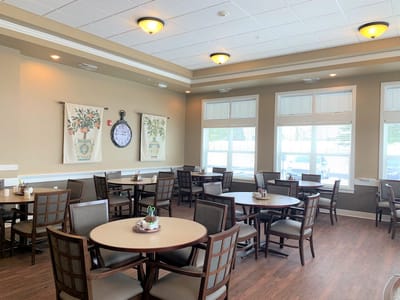 Dining room with tables and chairs, clock on the wall