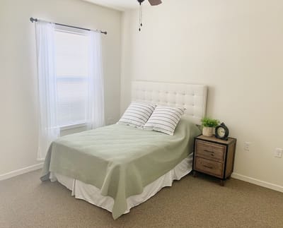 Cozy bedroom with a bed, nightstand, and window