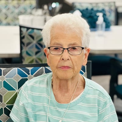An elderly woman sitting in a communal area
