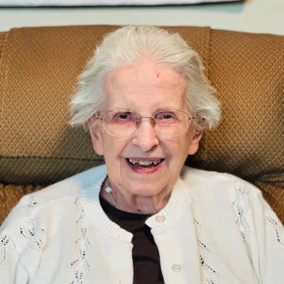 Senior resident smiling in a cozy chair