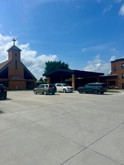 Exterior view of Pleasantview Assisted Living building with vehicles in parking lot