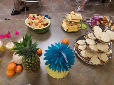 A table set with colorful fruit and desserts for residents