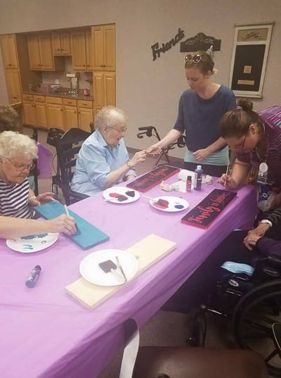 Residents participating in a craft activity at a communal table.