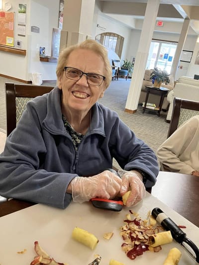 Resident enjoying a cooking activity in the common area
