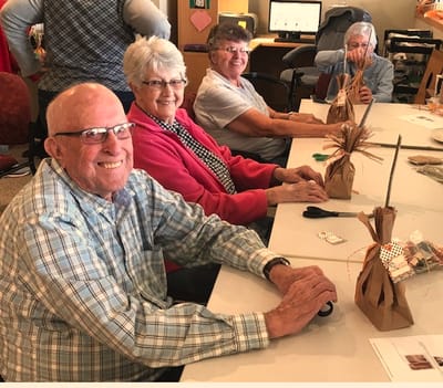 Residents engaging in a crafting activity at a communal table