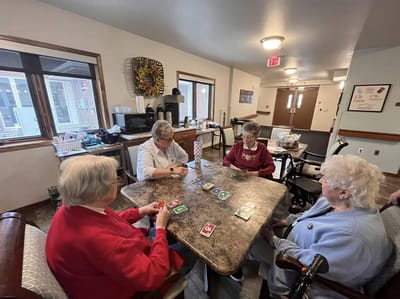Residents engaging in a card game in an activity room