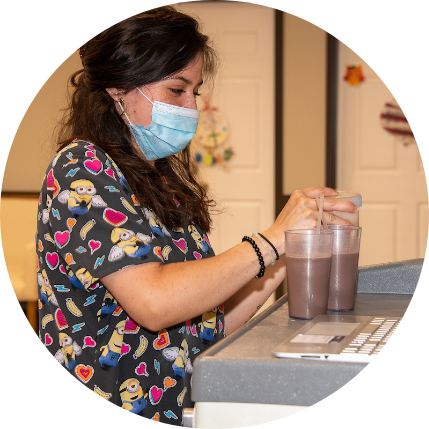 Staff member preparing drinks in a facility kitchen