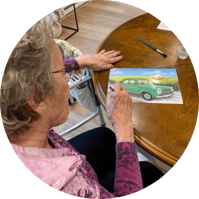 Resident enjoying an art activity at the table