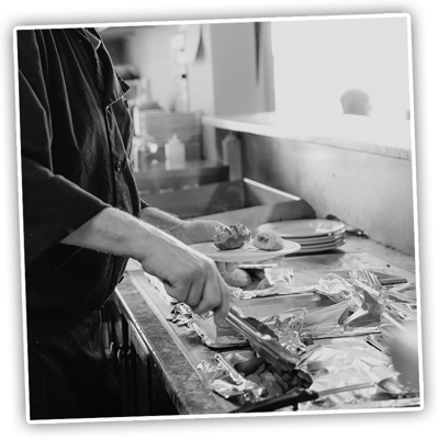 A staff member serving food in a kitchen area