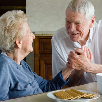 A smiling elderly couple enjoying a meal together