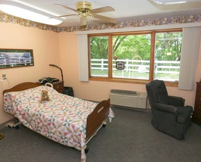 A cozy resident room with a bed and window view