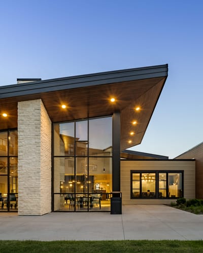 Modern facility exterior with large windows and landscaping