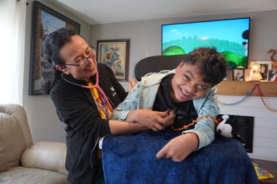 A caregiver and a smiling child in an activity room