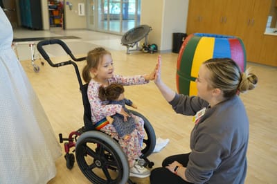 Child engaging with staff in a common area