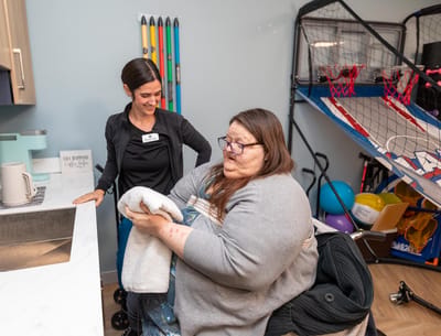 Staff assisting a resident in an activity room