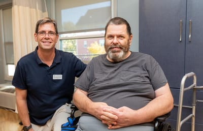 Staff member posing with a resident in a facility