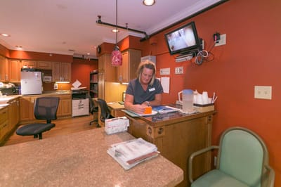 Staff member at reception desk in an interior setting