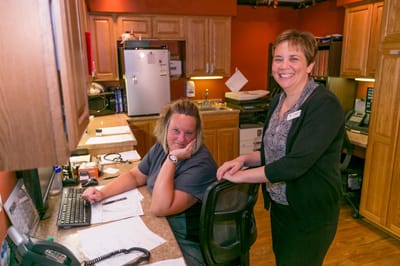 Two staff members smiling in a reception area