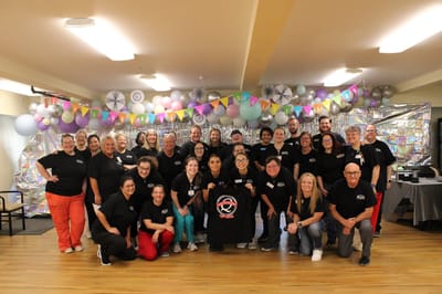 Staff and residents celebrating in a vibrant common area