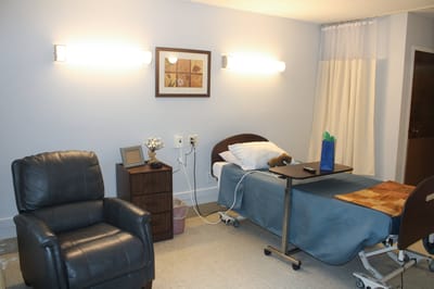 A cozy resident room with a bed and seating area
