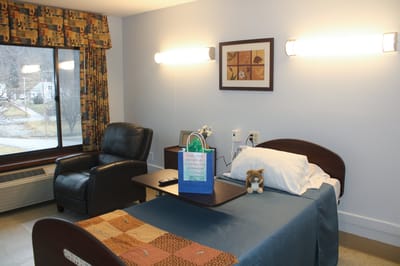 A single resident room with bed and seating area