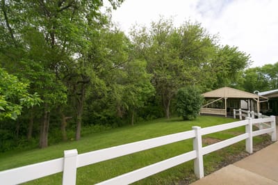 Scenic view of a grassy area with trees and a gazebo
